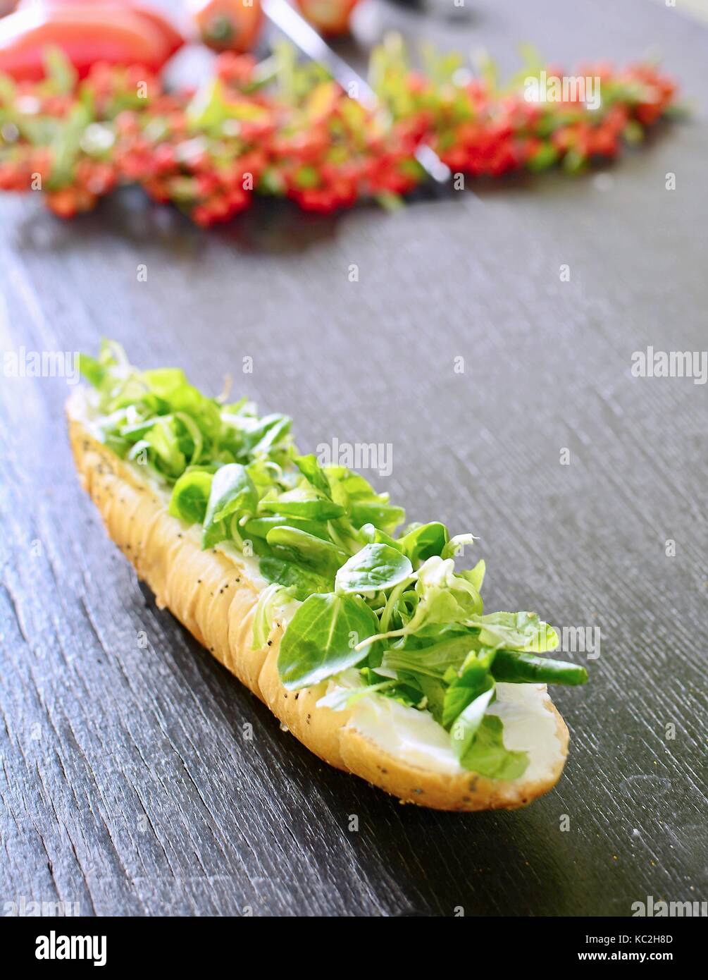 Fresh healthy white bread roll with Valerianella locusta salad. Stock Photo