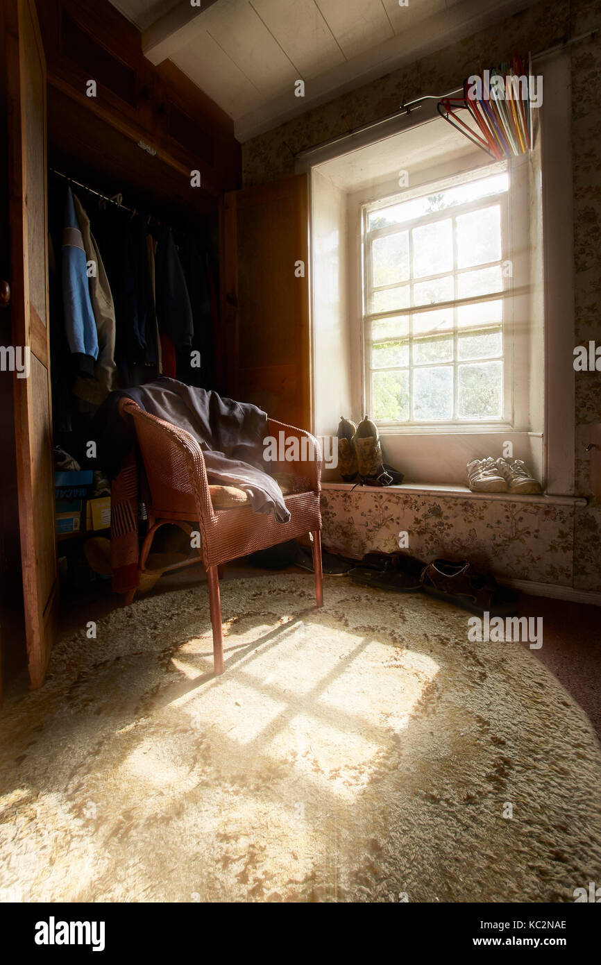 Quaint house interior; rooms with shadows and sunlit windows.  Old feel and cluttered rooms with chairs, books, CD's and house hold items. Stock Photo