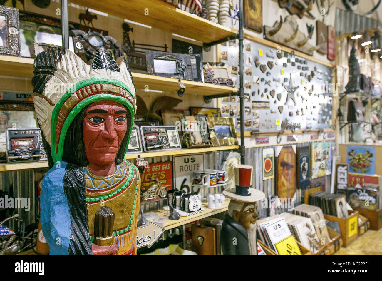 Wooden statues of an Indian stands in front of shelves of a Wild West themed store in Manhattan. Stock Photo