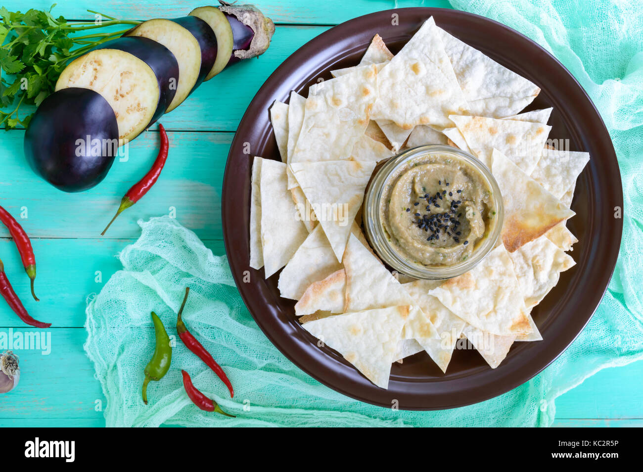 Light dietary pate from eggplant. Baba ganush is an Asian dish. Serve with thin lavash on a ceramic bowl. Top view. Stock Photo