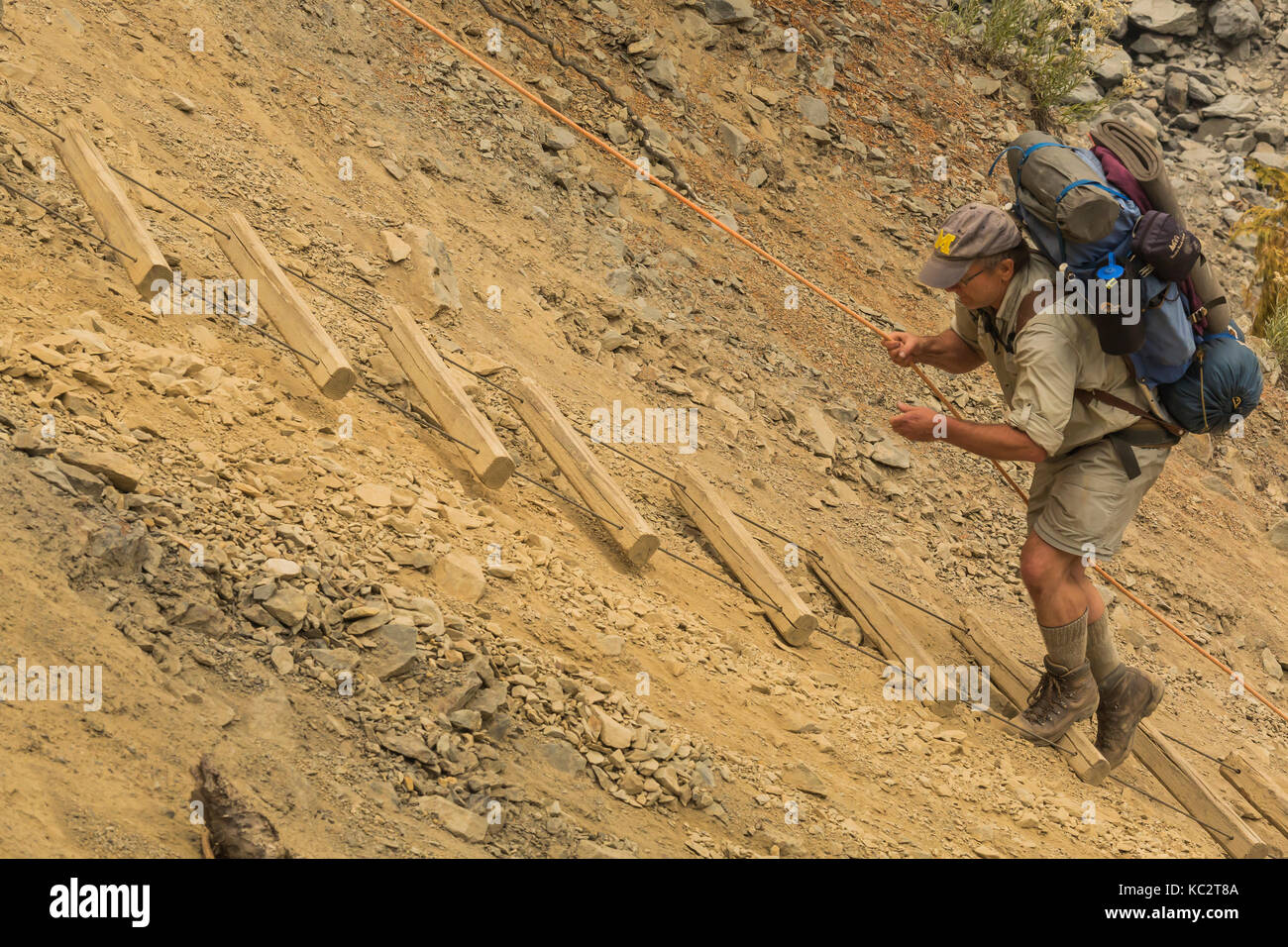 Trekking Ramp Down Backpacker Lee ascending a long, steep rope ladder along the wall of a ...