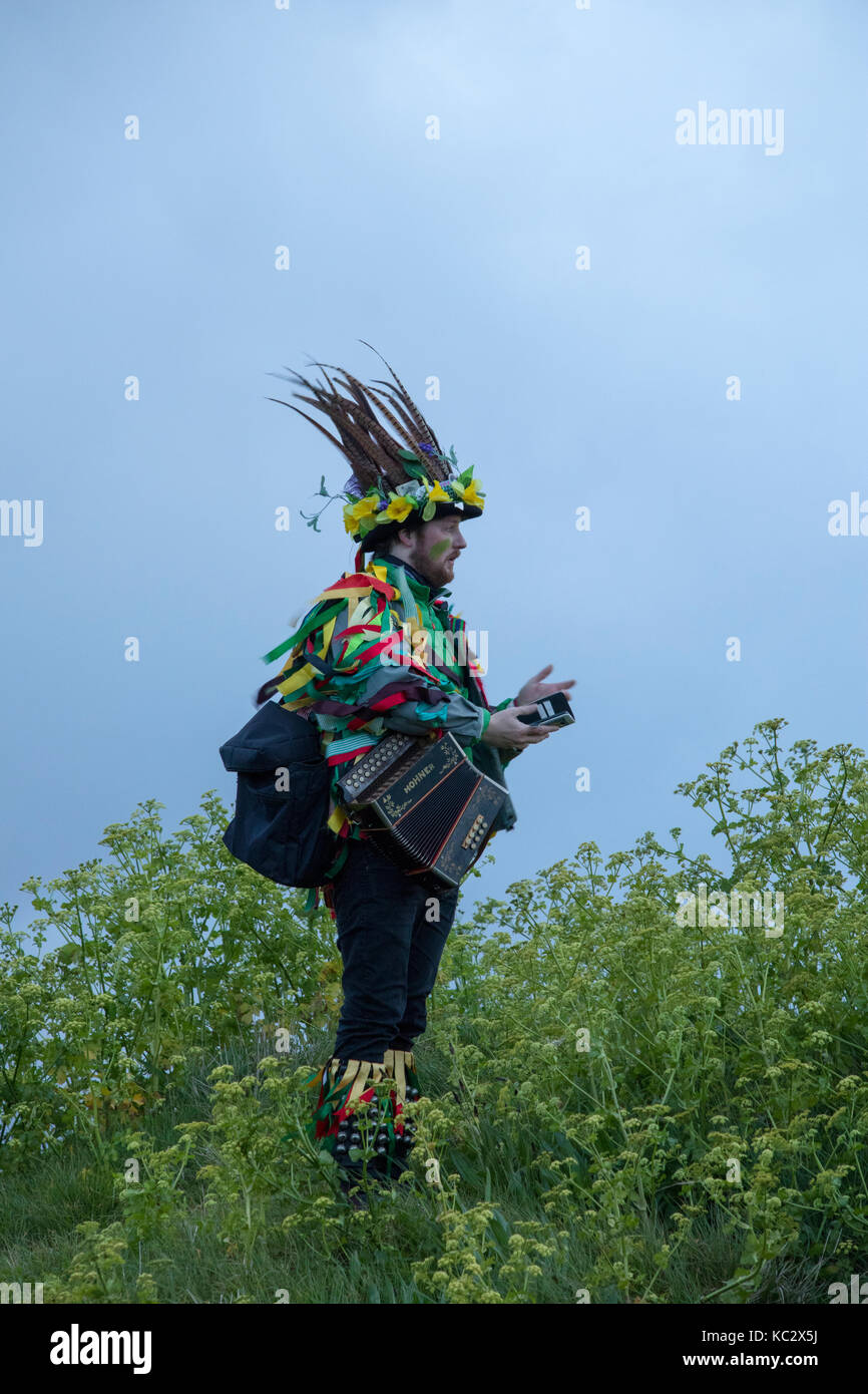 Lone watcher in costume at dawn on May Day on the West Hill in Hastings, East Sussex, England Stock Photo