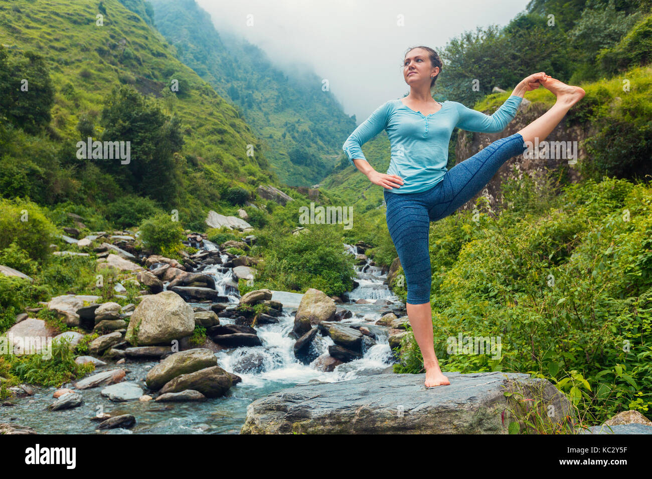 Woman doing Yoga asana outdoors at waterfall Stock Photo - Alamy