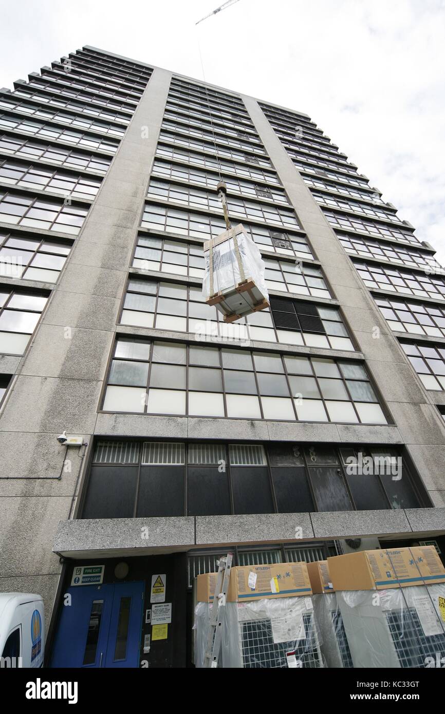 Lifting air conditioning units by crane onto the roof of a sky scraper