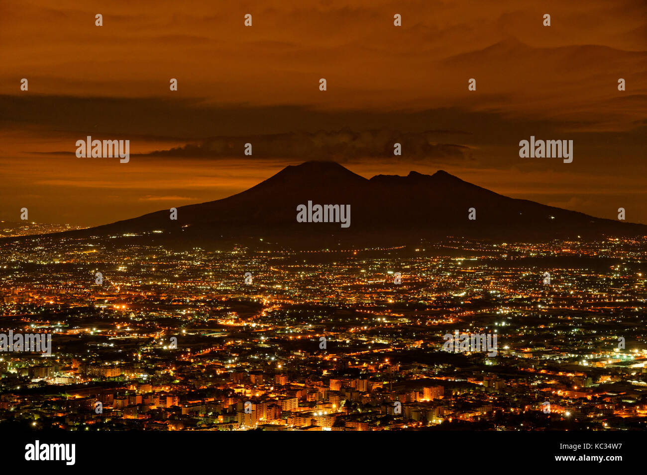 Mount Vesuvius silhouetted by the glow from the Naples conurbation in Campania Province, Southern Italy. Stock Photo