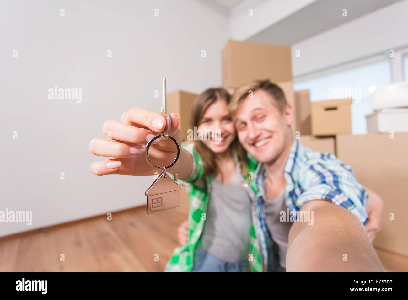 Happy couple showing keys of new home indoor Stock Photo - Alamy