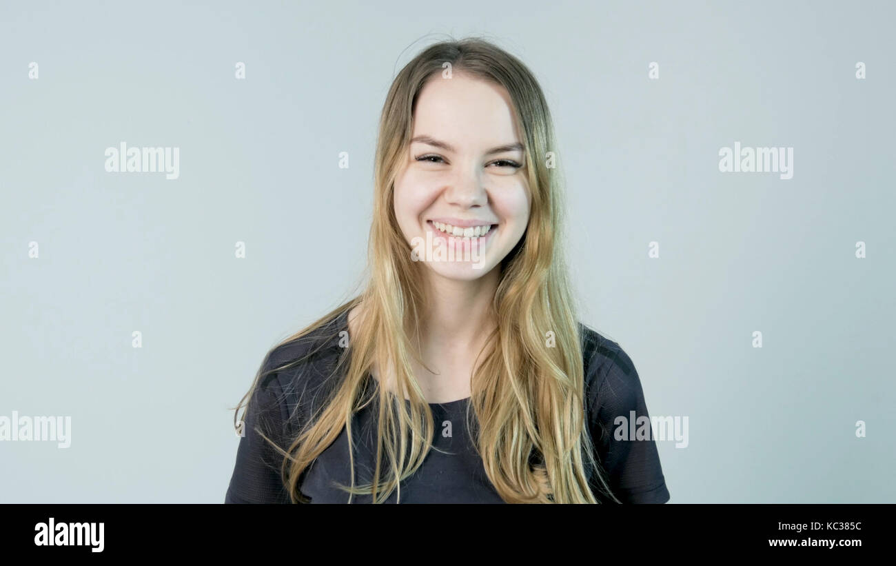 Young beautiful cute cheerful girl smiling looking at camera over white ...