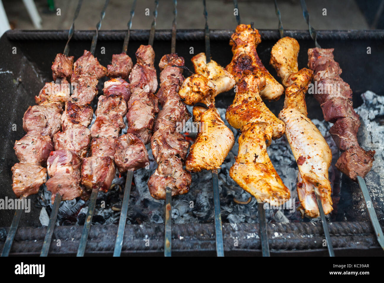 travel to Crimea - skewers with lamb pieces and chicken wings shish-kebab on grill in tatar outdoor cafe Stock Photo
