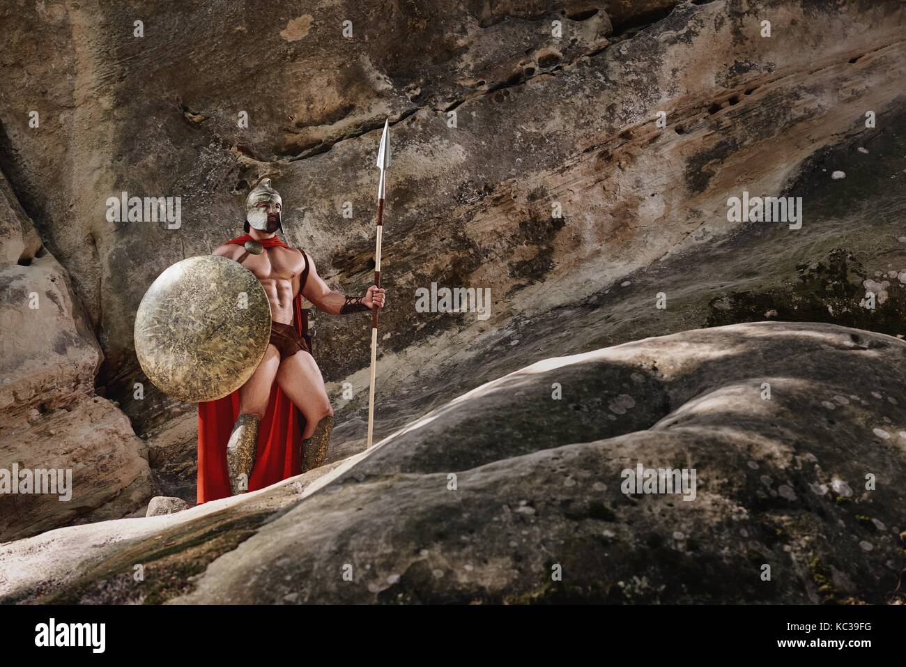 Gladiator with spear on rocks Stock Photo