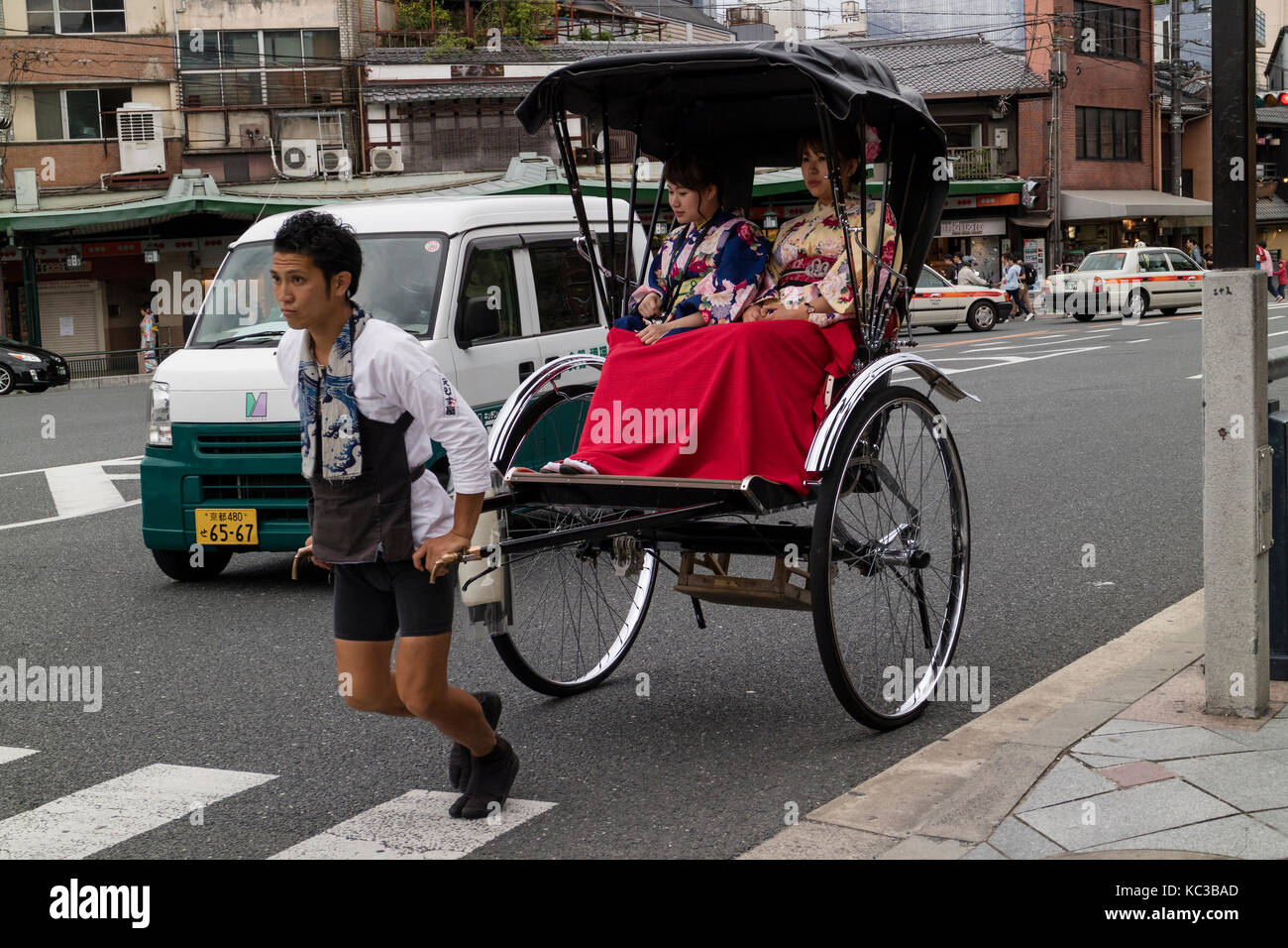 Kyoto, Japan -  May 17, 2017: Traditional human power rickshaw carrying women in kimono Stock Photo