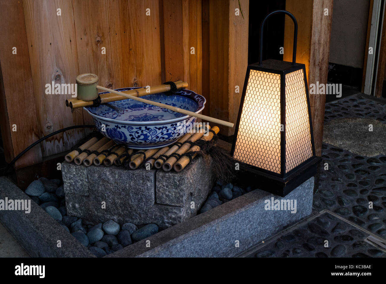 Kyoto, Japan -  May 17, 2017: Traditional water bowl and ladle for purifying hands and a lantern at twilight Stock Photo