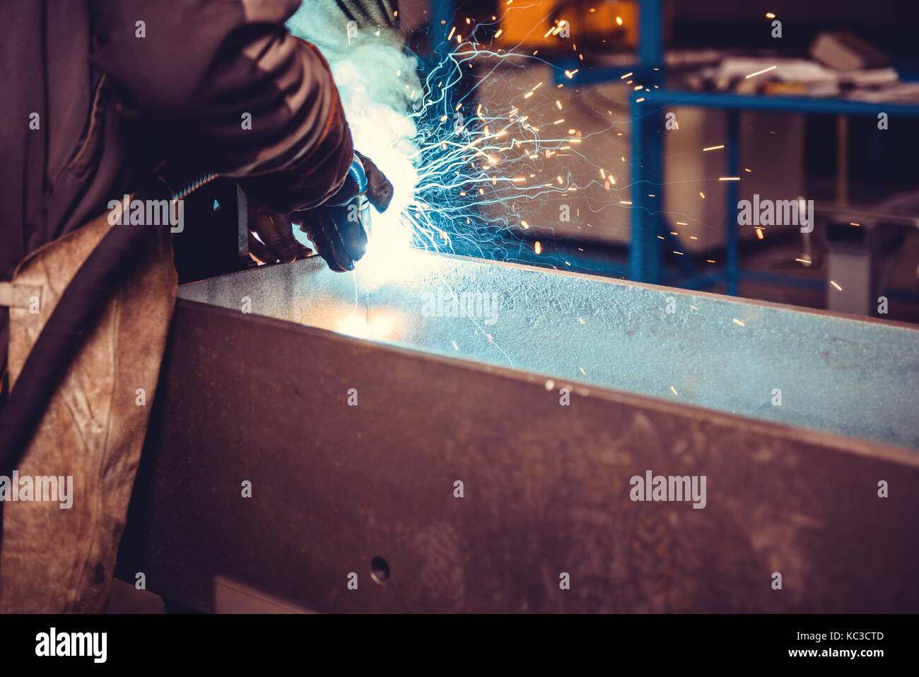 Industrial Welder With Torch in big hall welding metal profiles Stock Photo