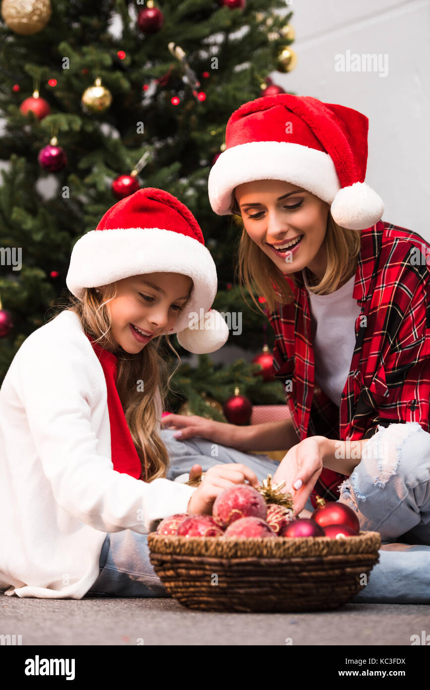 mother and daughter decorating christmas tree Stock Photo - Alamy