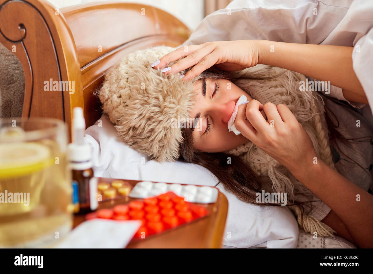 Sick young woman on the bed in the room Stock Photo