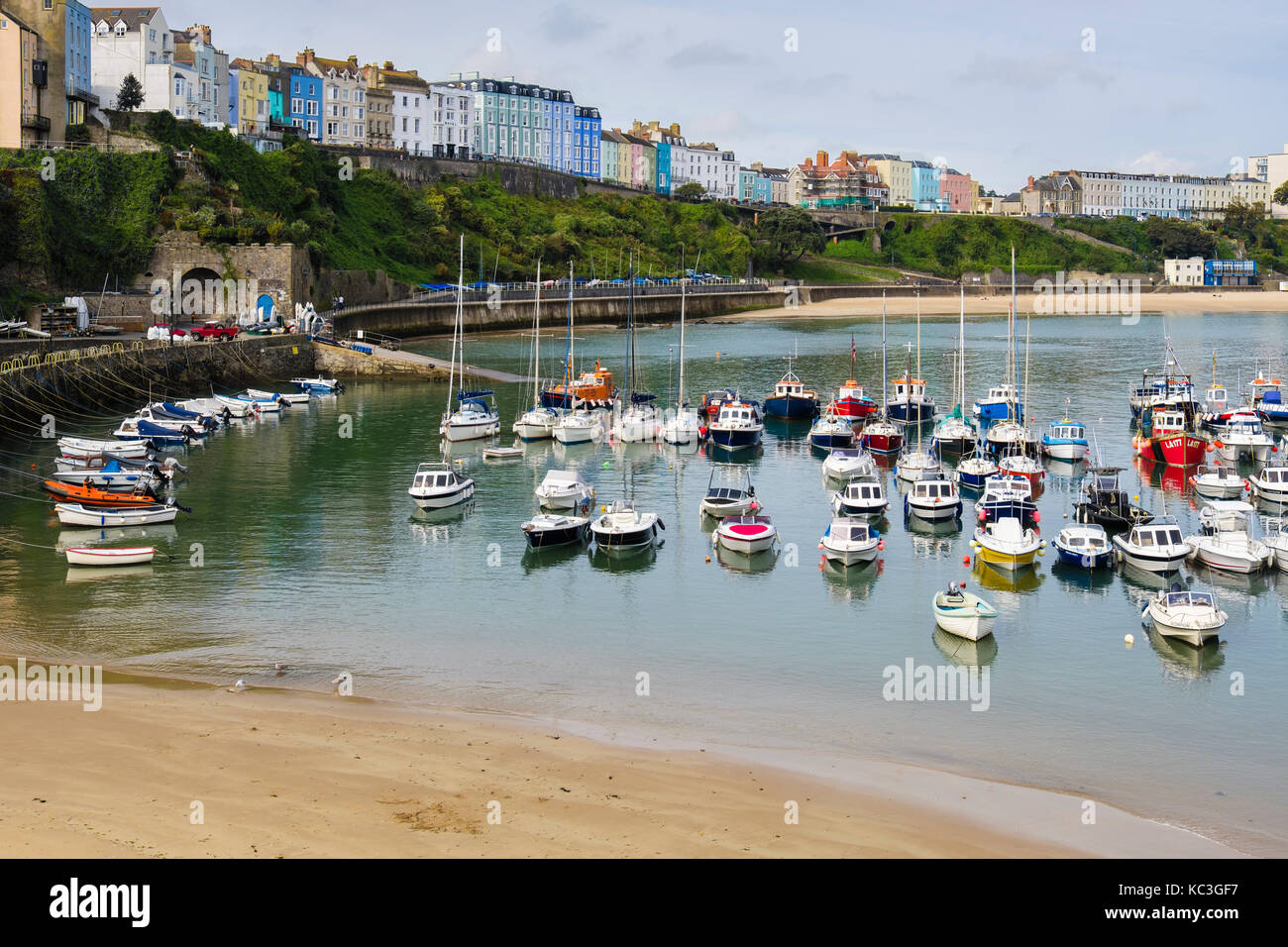 Boats moored in the harbour at high tide with colourful hotels overlooking on seafront. Tenby, Carmarthen Bay, Pembrokeshire, Wales, UK, Britain Stock Photo