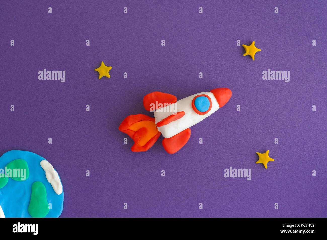Space Rocket Blasting Off For New Ideas. Earth, space rocket and stars are made out of play clay (plasticine). Stock Photo