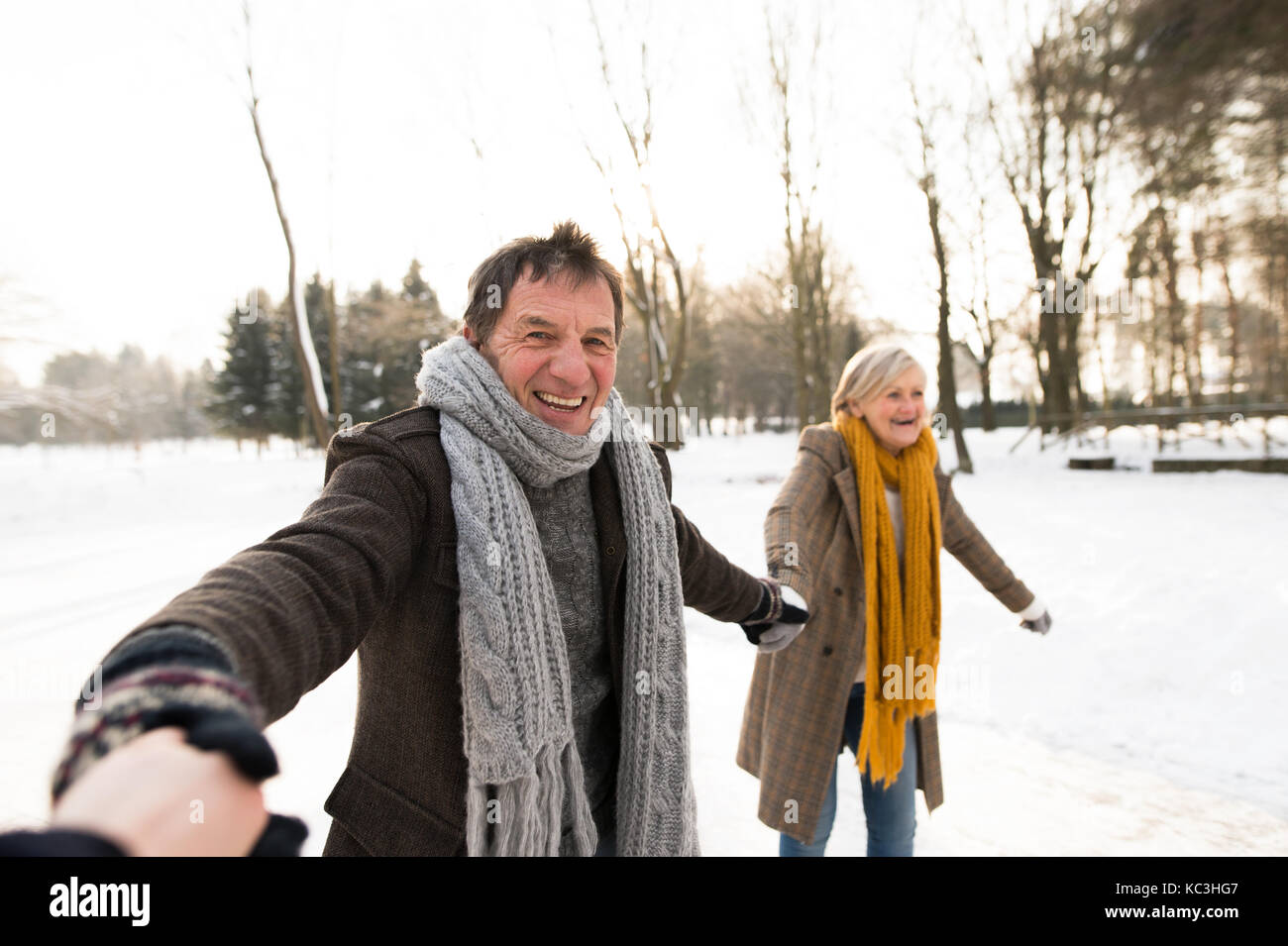 Senior couple in sunny winter nature ice skating. Stock Photo