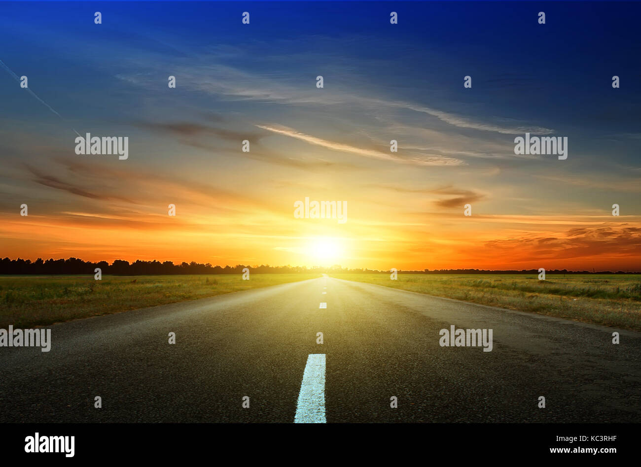 Asphalt road among the fields at sunset Stock Photo - Alamy