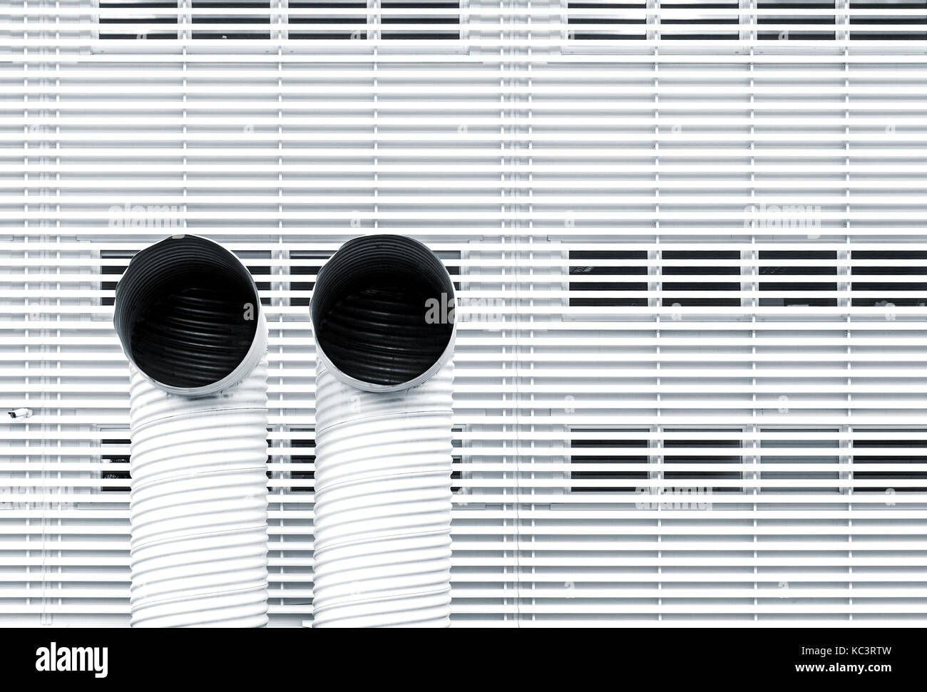 Abstract architecture picture with two ventilation pipes against striped metal facade Stock Photo