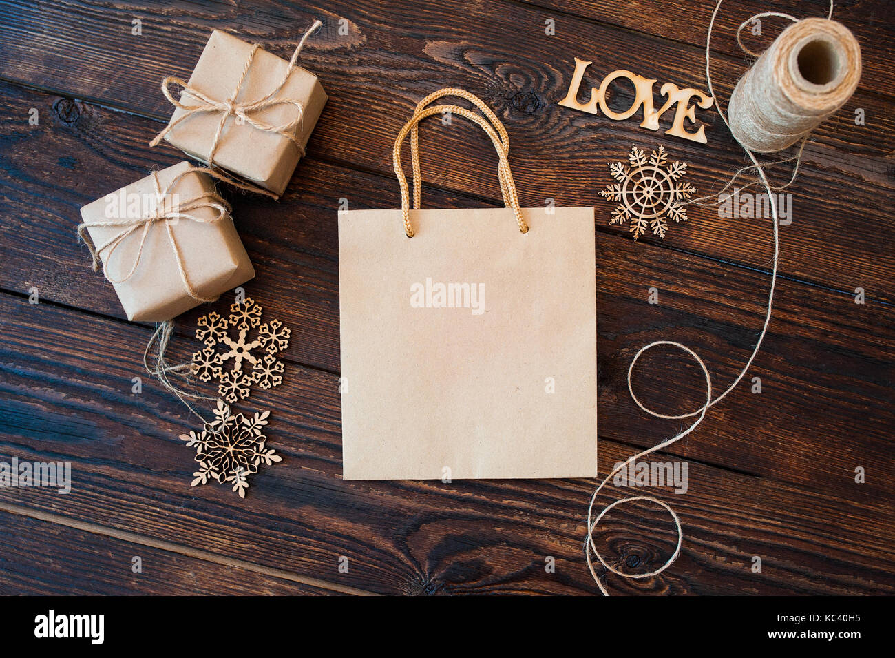 Mockup Paper bag from kraft paper and Christmas gift boxes on a wooden background Stock Photo