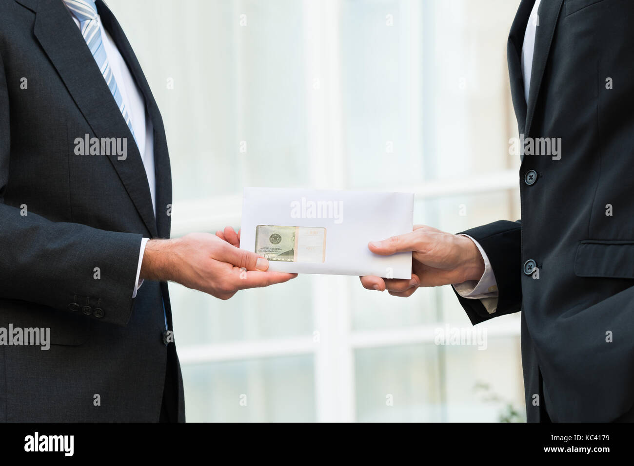 Midsection of businessman giving bribe to partner outdoors Stock Photo