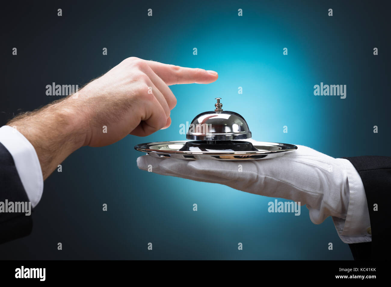 Cropped image of businessman ringing in service bell held by bellboy ...
