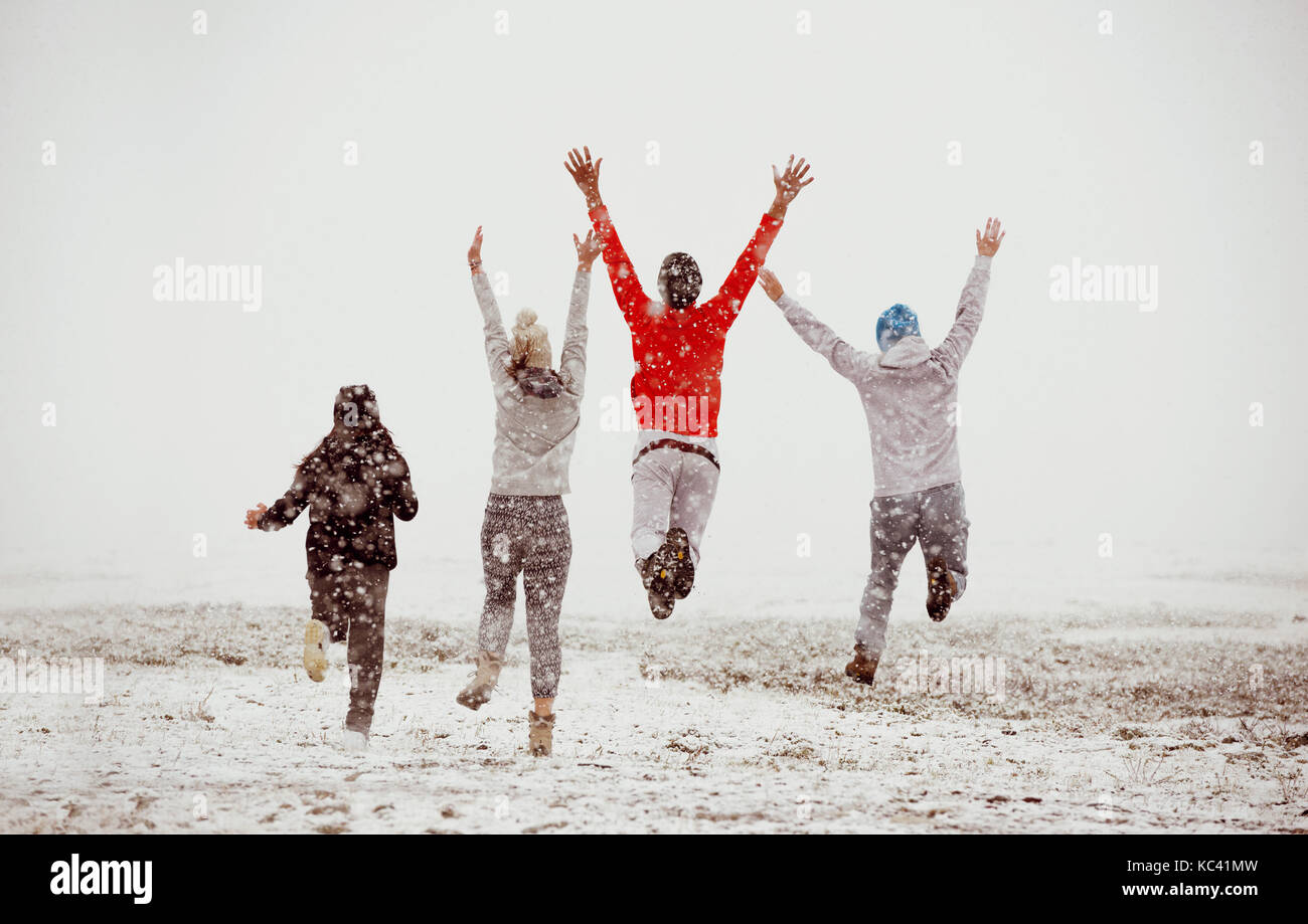Happy friends friendship run jump first snow Stock Photo