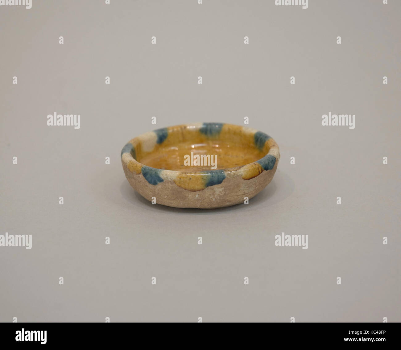 Dish, Tang dynasty (618–907), China, White clay, decorated in blue and yellow lead silicate glaze, H. 5/8 in. (1.6 cm); Diam. 2 Stock Photo