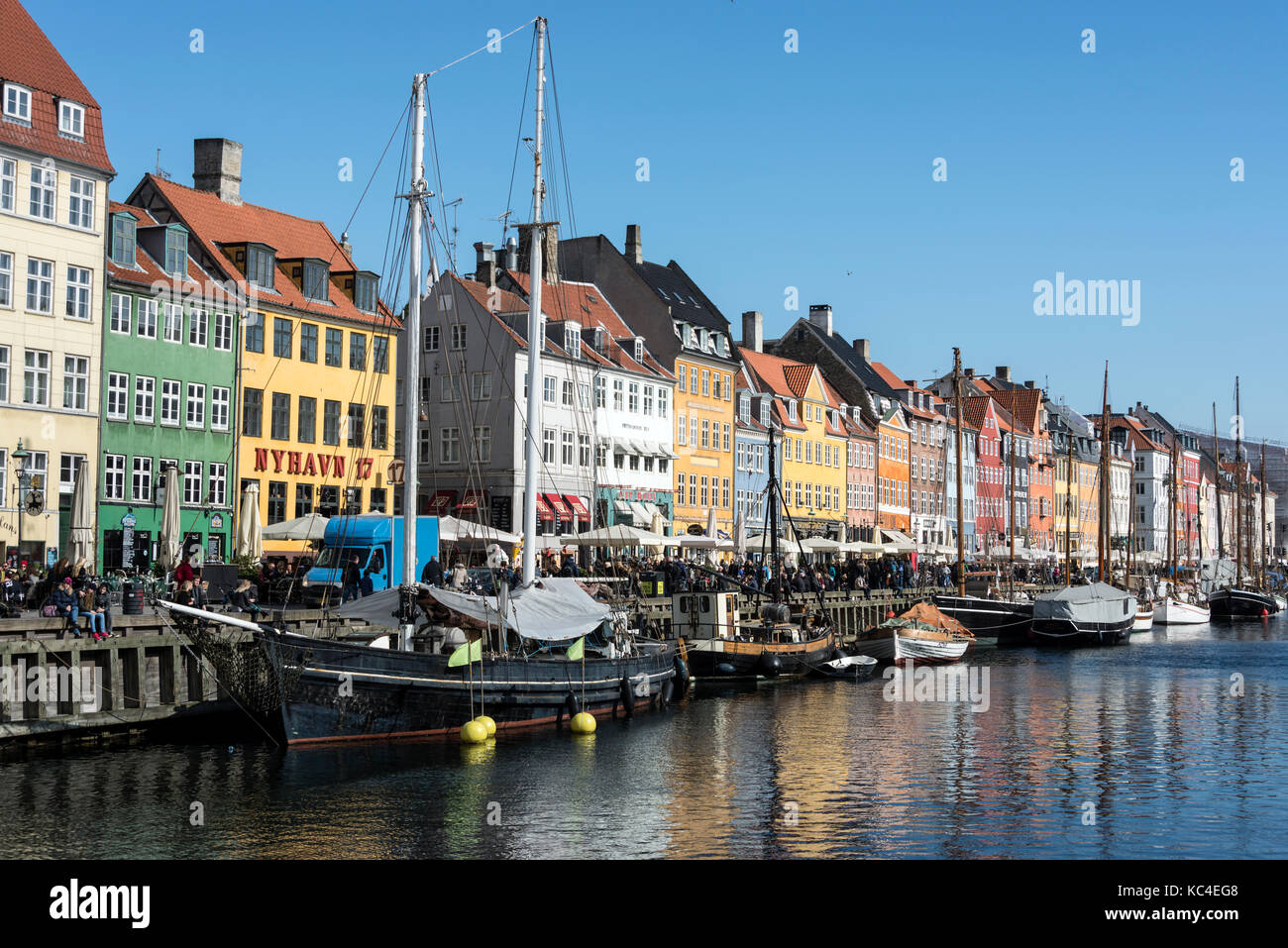 Nyhavn ( New Harbour) in central Copenhagen in Denmark.  It is a very popular eating haunt lined with brightly coloured 17th and early 18th century to Stock Photo