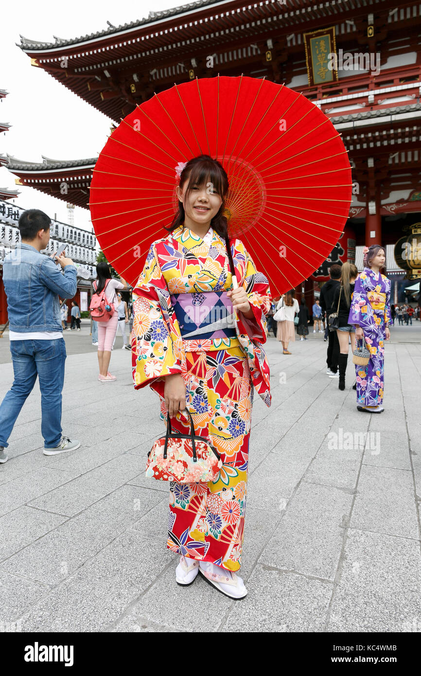 A Chinese tourist dressed in traditional Japanese kimono poses for a photograph at the Sensoji temple in Asakusa district during the China National Day Golden Week holiday on October 2 2017 Tokyo