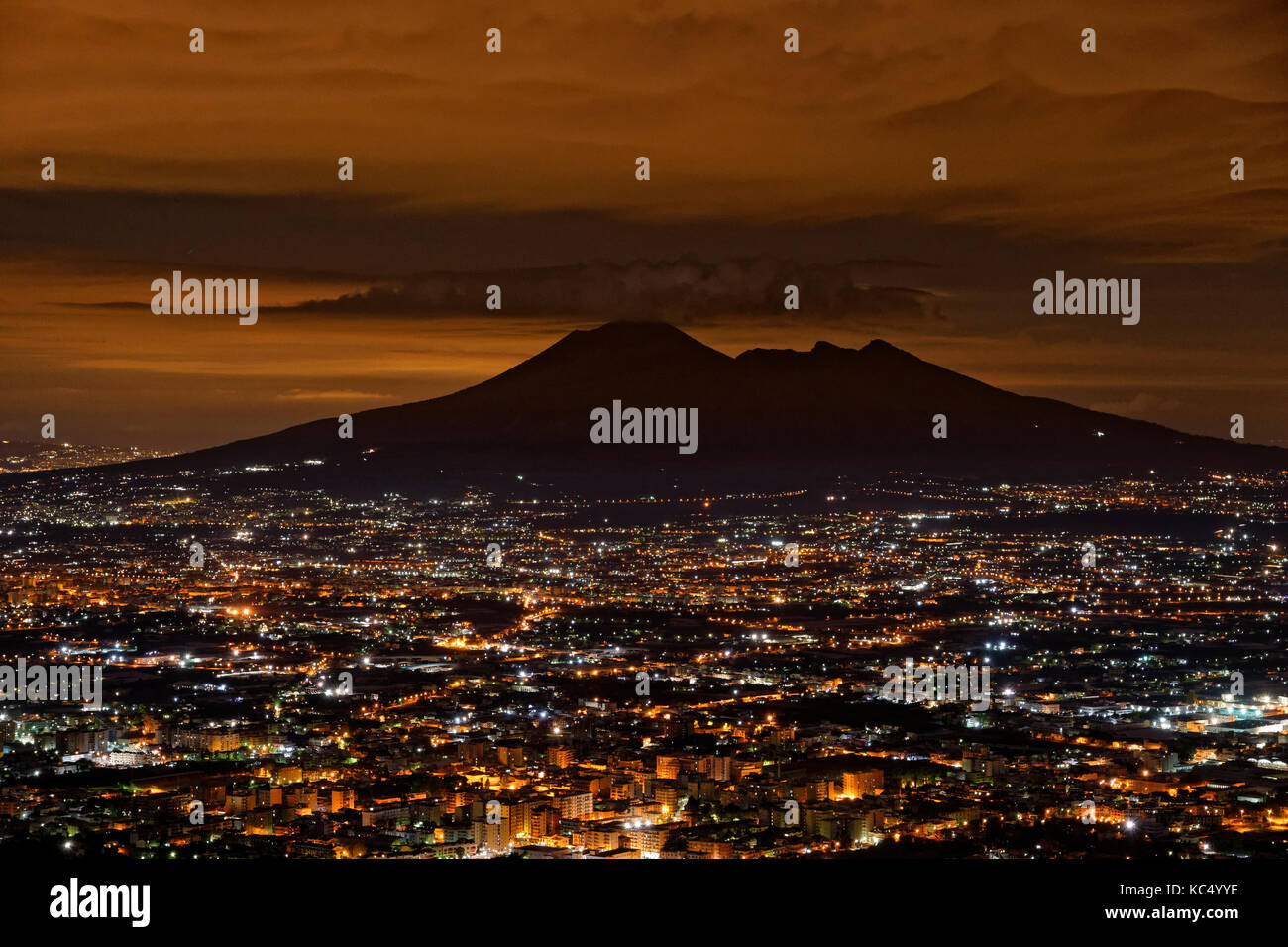Mount Vesuvius silhouetted by the glow from the Naples conurbation in Campania Province, Southern Italy. Stock Photo