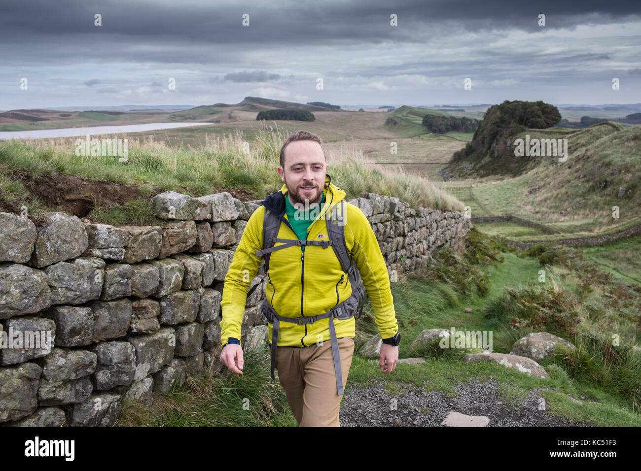Walker on Hadrians Wall , Northumberland , UK Stock Photo