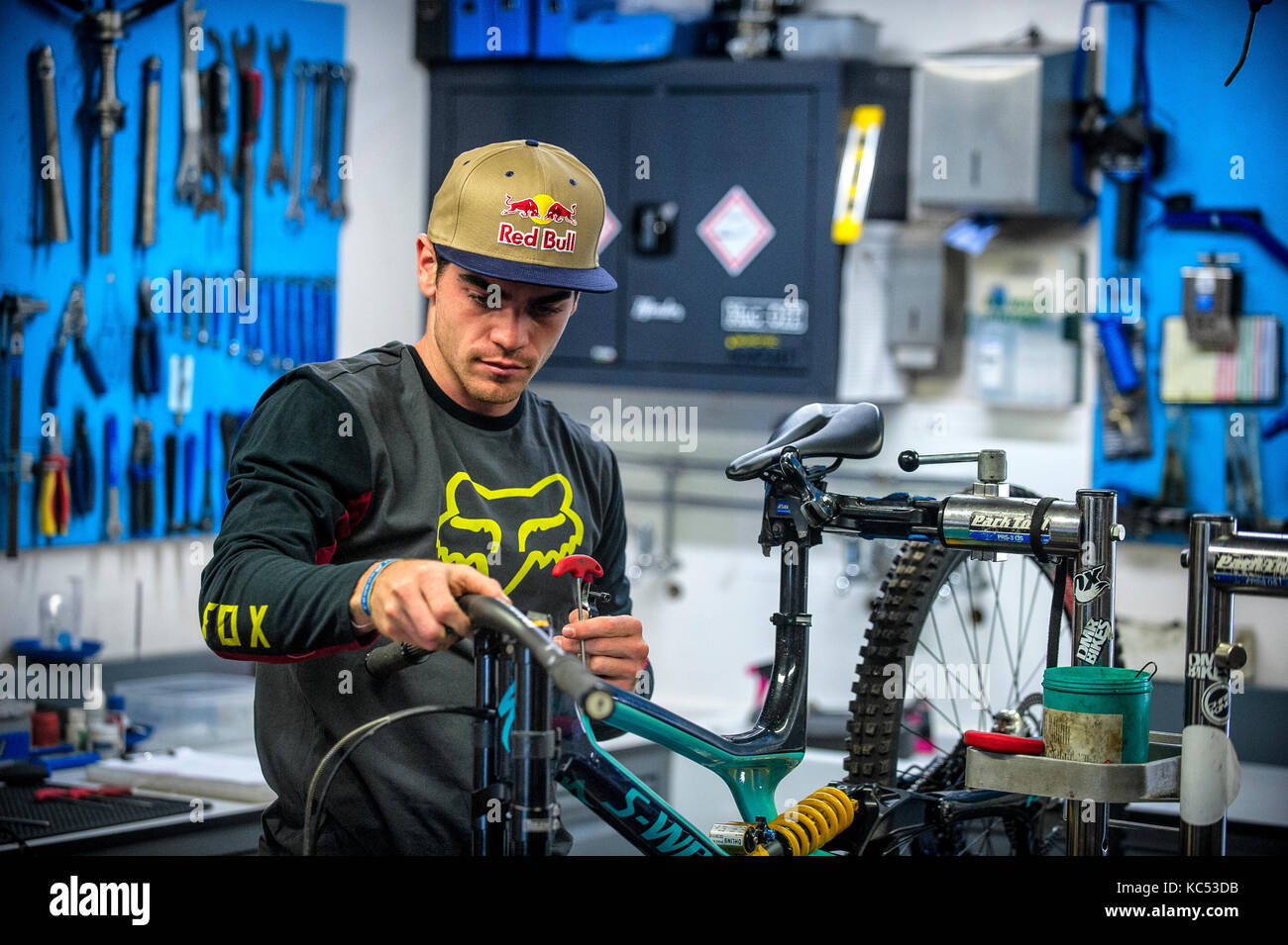 Professional downhill mountain biker Loïc Bruni. 2015 and 2017 UCI downhill mountain bike World Champion. Pictured in a workshop building his bike. Stock Photo