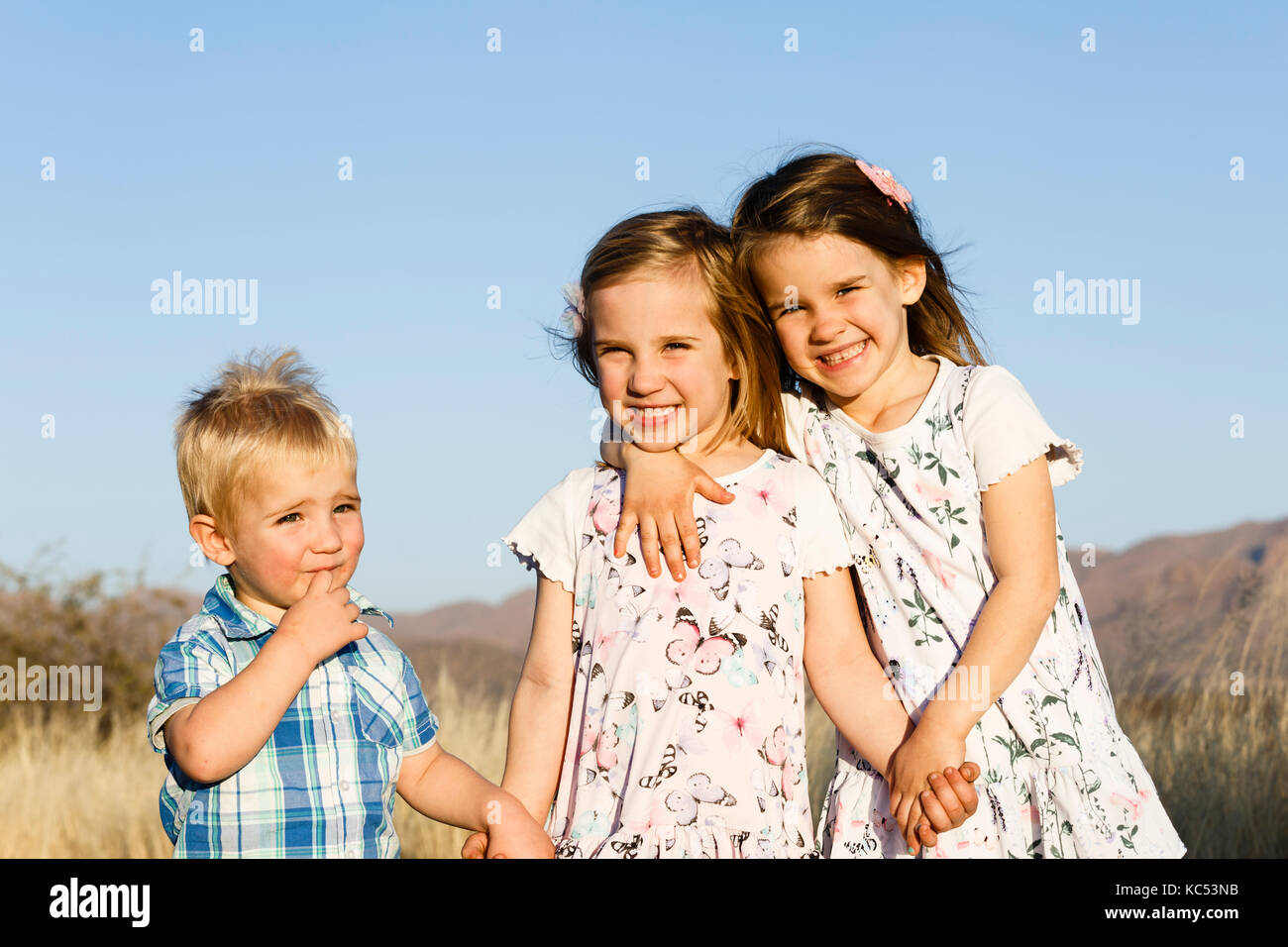 Three siblings, boy and two girls, toddlers, Namibia Stock Photo