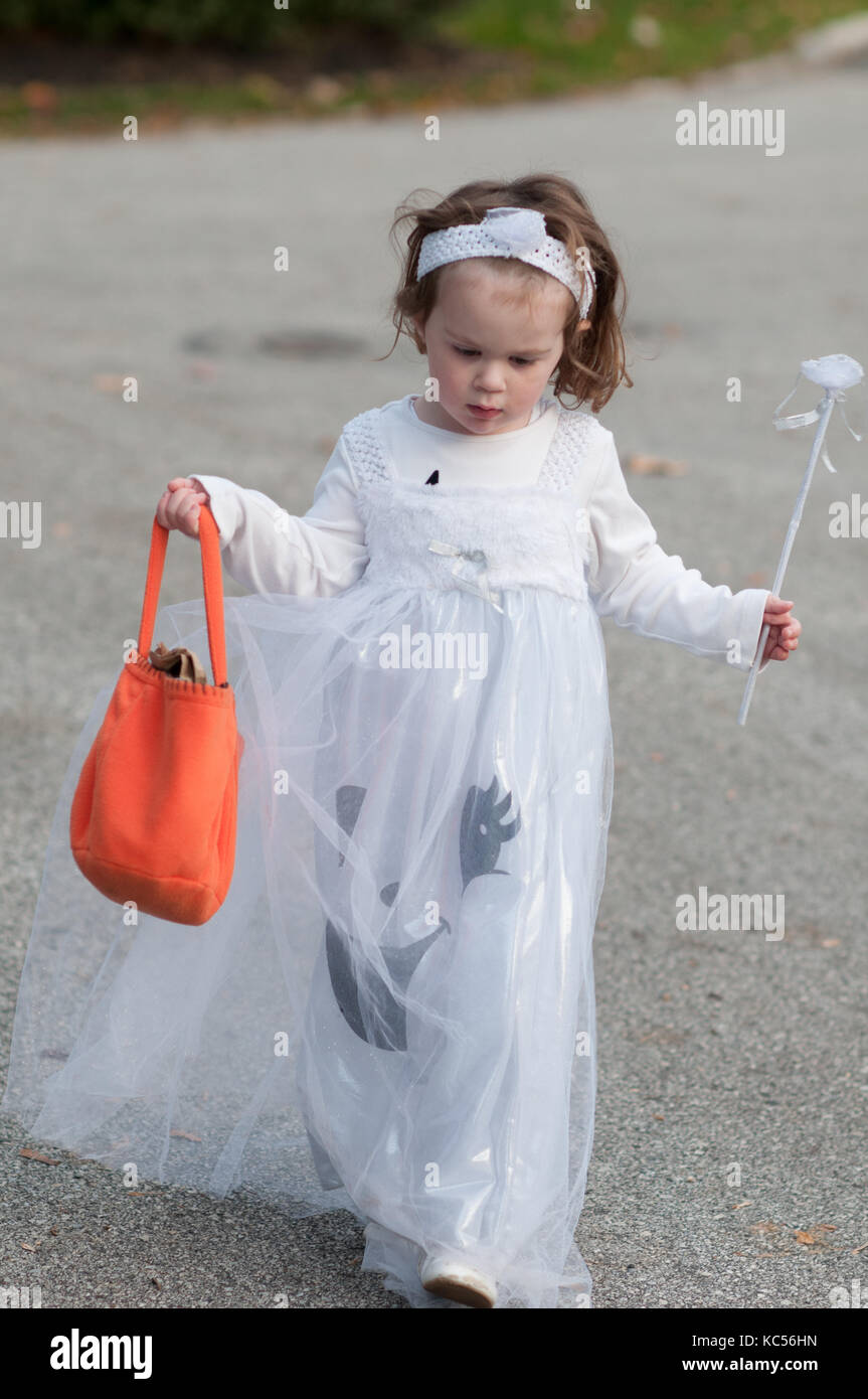 View of Little girl in ghost costume having fun at Halloween trick or treat Stock Photo