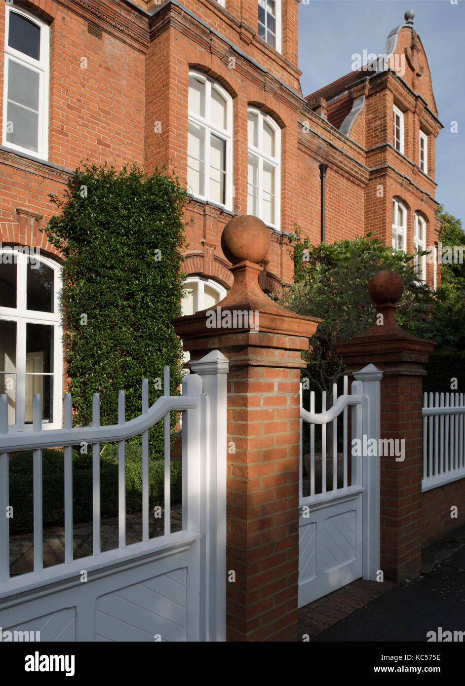 Ball finials on brick pillars and a palisade gate at numbers 3 and 5 Queen Anne’s Grove, Bedford Park, Chiswick, London, UK Stock Photo