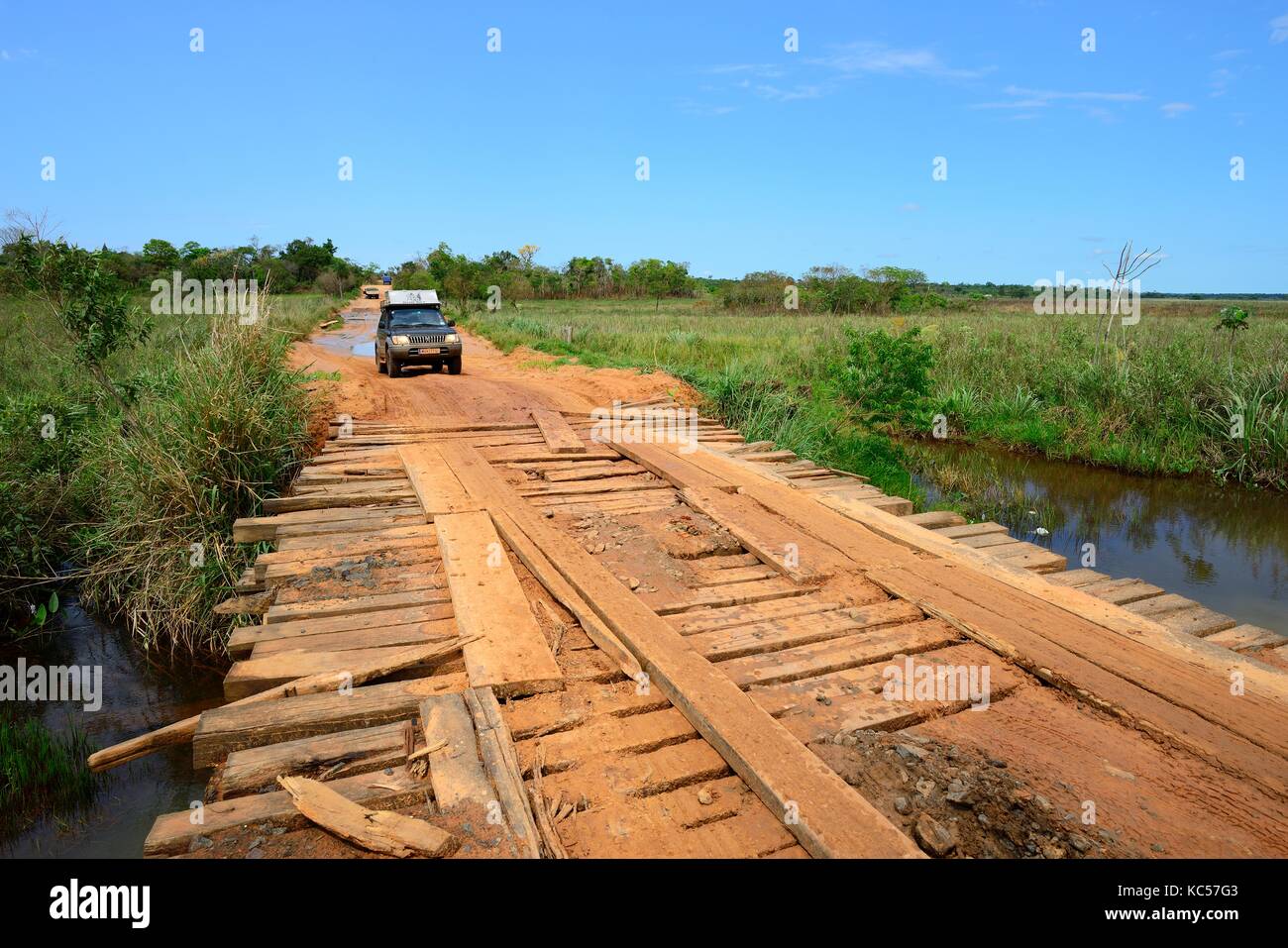 All-terrain vehicle crosses simple wooden bridge, main road at Santa Rosa del Aguaray, San Pedro, Paraguay Stock Photo