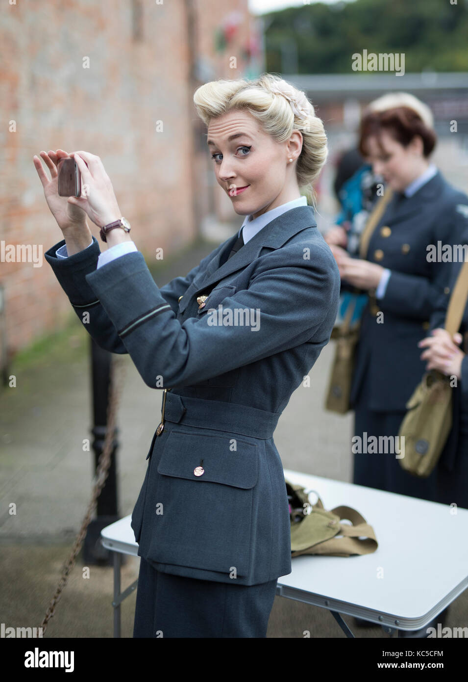 Girl using mobile phone and wearing 1940's vintage RAF uniform Stock Photo