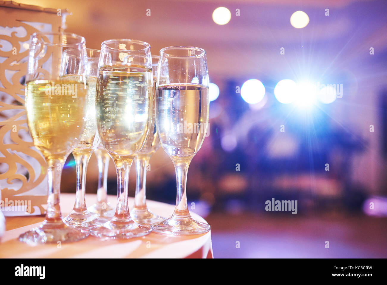 A lot of wine glasses in blue light with a cool delicious champagne or white wine at the bar