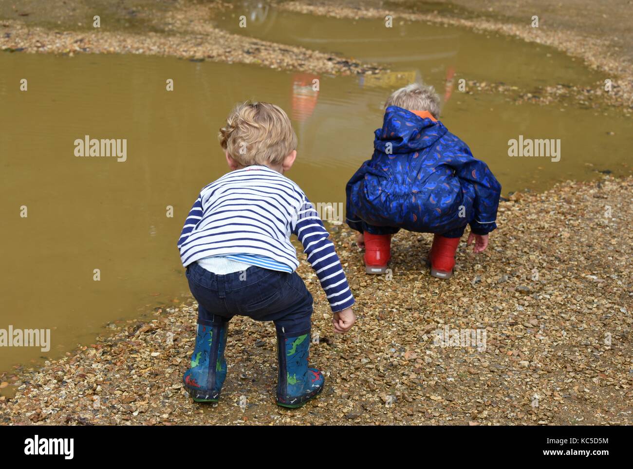 Two children before jumping into a puddle at Blashford Lakes Nature Reserve. Stock Photo