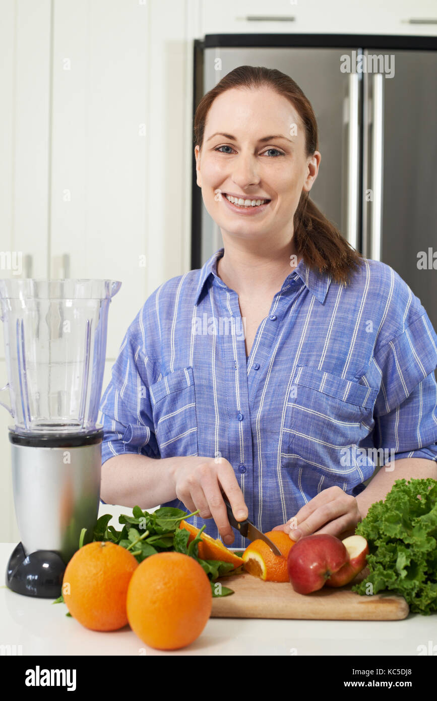 Portrait Of Woman Chopping Fruit To Put Into Juicer Stock Photo Alamy