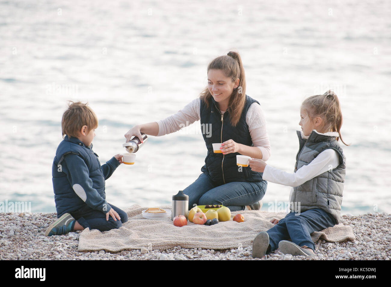 Father dad pours hot coffee tea from thermos into the mug on a family  picnic in the mountains. Child school boy kid is watching his dad filling  the Stock Photo - Alamy