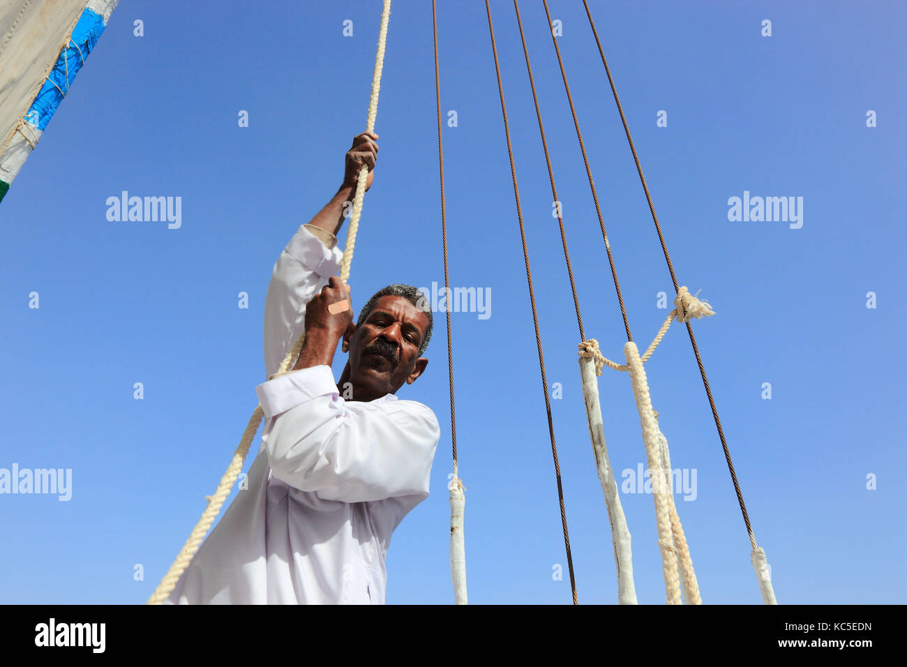Arab man hoist the sails of a sailboat, felucca, Egypt Stock Photo Alamy
