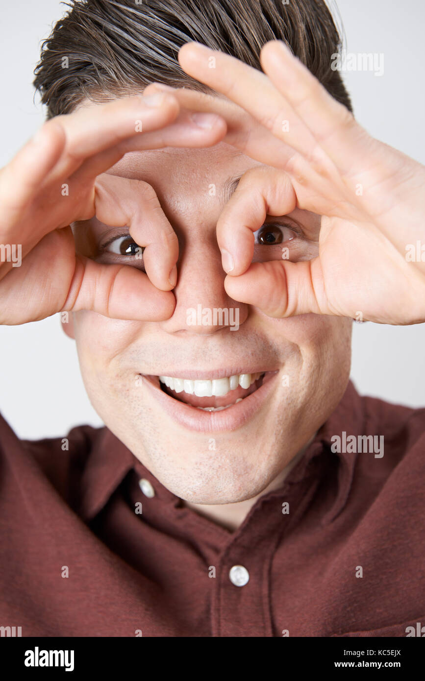 Studio Shot Of Man Making Spectacle Shape With His Hands Stock Photo