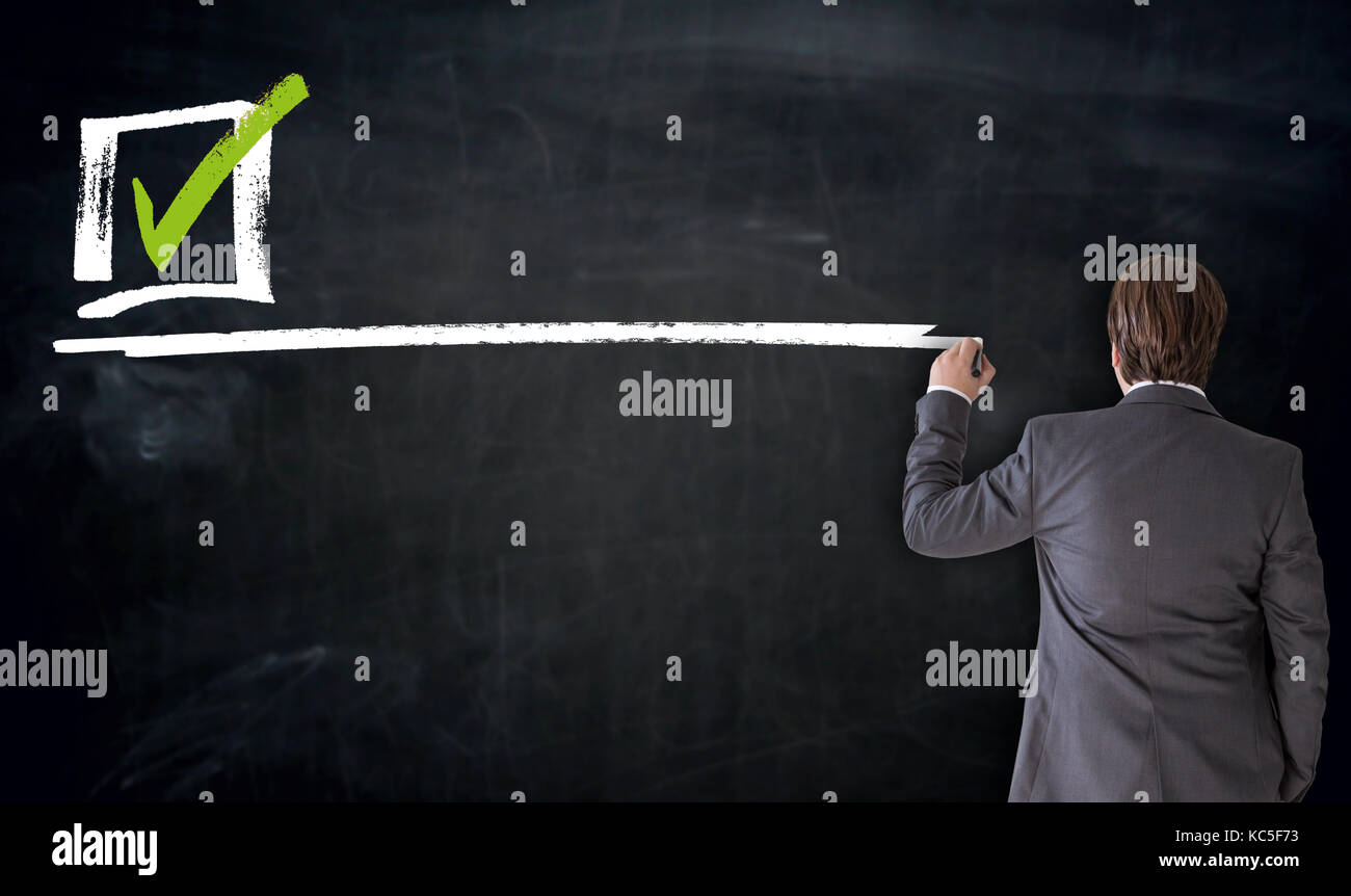 Businessman writing checkbox on blackboard concept Stock Photo - Alamy