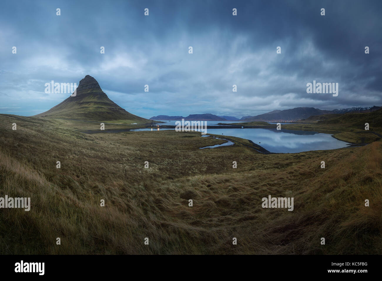 Panoramic photography of Kirkjufell mountain and the nearby lake in Iceland. Grass and lagoon in Snaefellnes peninsula. Stock Photo