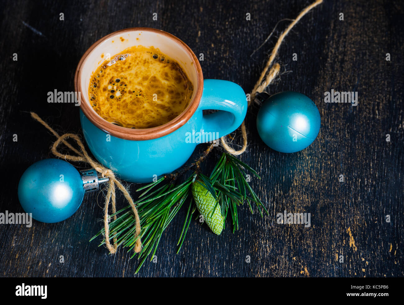 Mug of coffee with spices - cinnamon sticks and anise star with Christmas decor on dark wooden table with copyspace Stock Photo