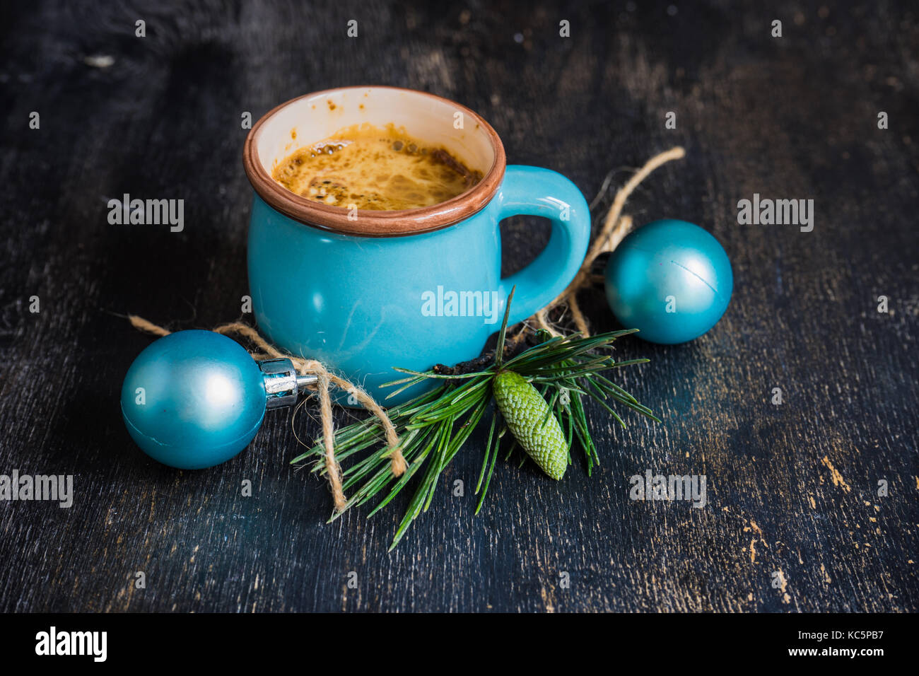 Mug of coffee with spices - cinnamon sticks and anise star with Christmas decor on dark wooden table with copyspace Stock Photo