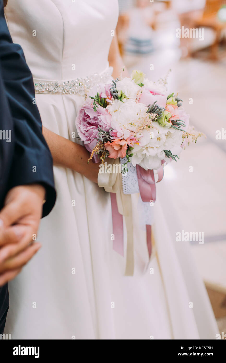 Close-up photo of the wedding bouquet of colourful peonies wrapped with ...