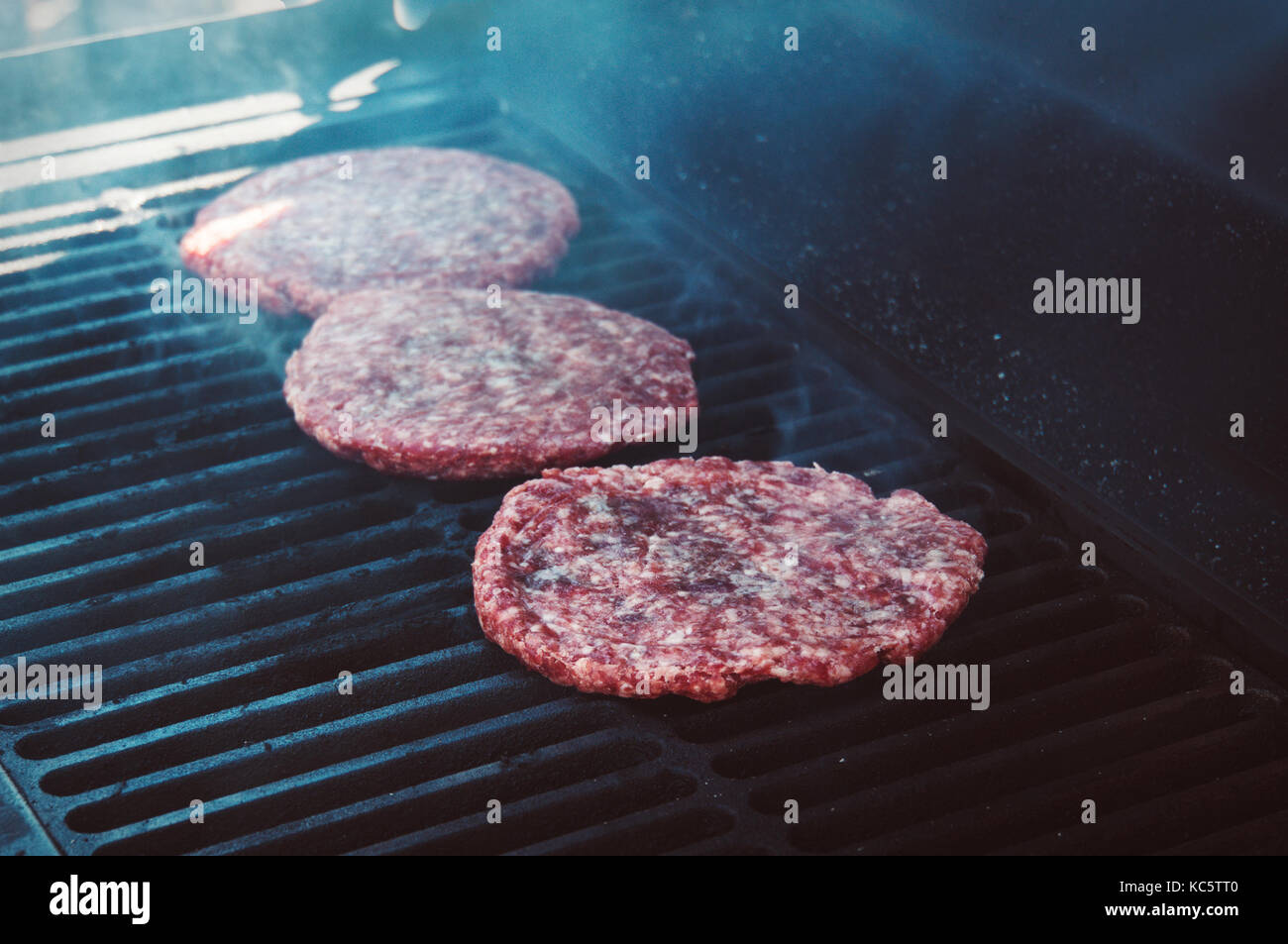 Burgers for the hamburger on Grill with Flames Cooked to Perfection